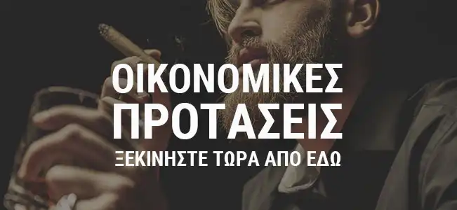 άντρας με μούσι που καπνίζει πούρο και κρατάει ένα ποτήρι ουίσκι στο χέρι
